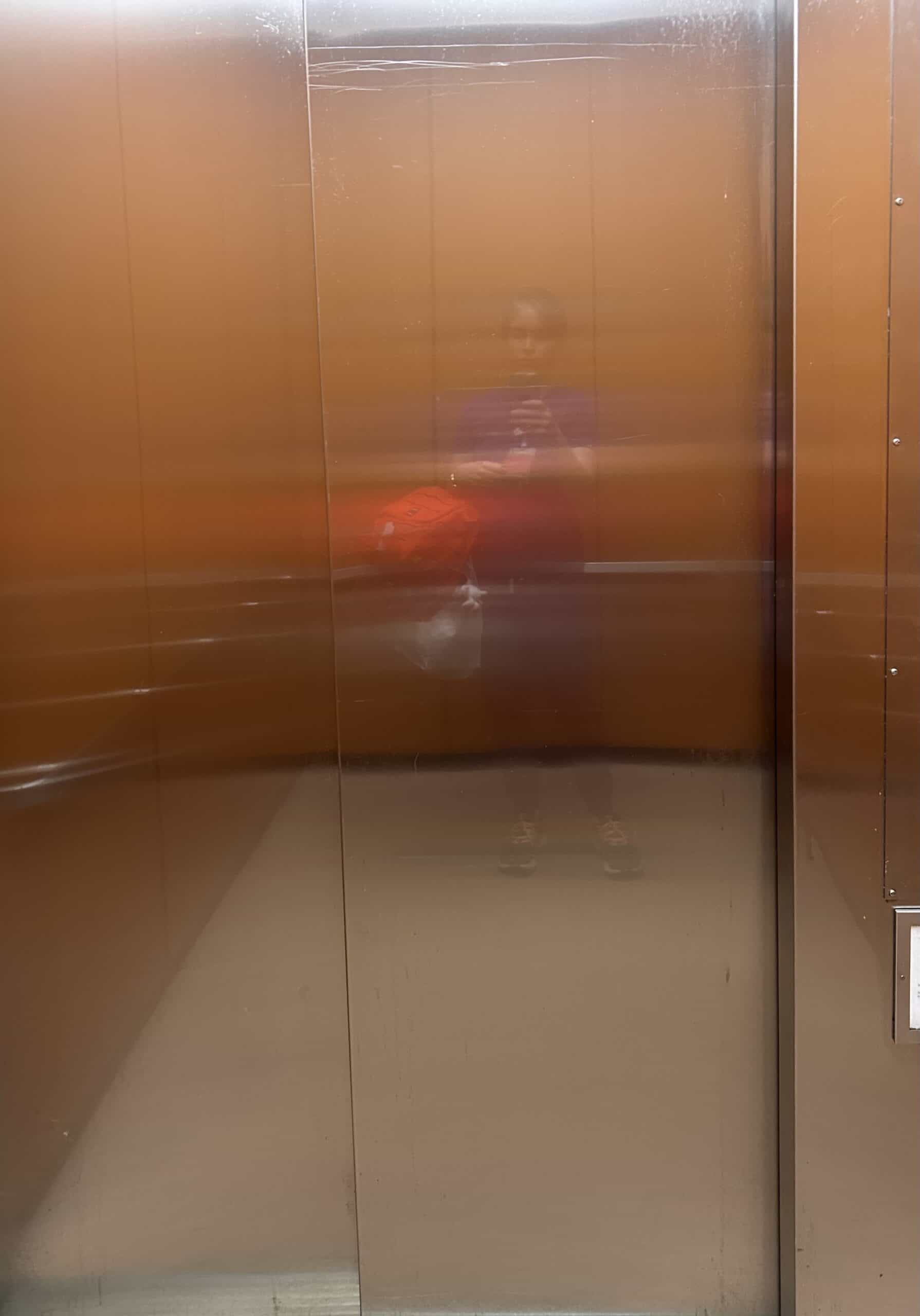 Kristen reflected in hospital elevator.